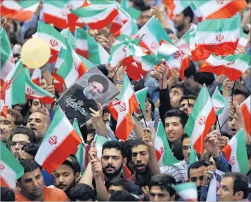  ?? Vahid Salemi Associated Press ?? SUPPORTERS rally in Tehran for Ebrahim Raisi, the archconser­vative challenger of Iranian President Hassan Rouhani. Raisi has pledged cash subsidies for the poor, whereas Rouhani has promised new jobs.