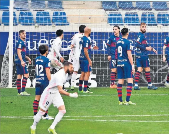  ??  ?? Los jugadores del Madrid festejan el gol del empate de Varane, que se adelantó de cabeza a la defensa del Huesca tras la falta de Benzema al larguero.