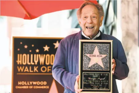  ?? Chris Pizzello / Associated Press 2017 ?? Actor George Segal poses with a replica of his star on the Hollywood Walk of Fame at a ceremony in Los Angeles in 2017.