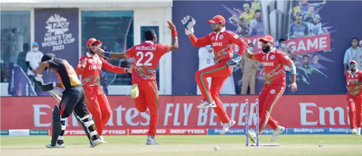  ?? — Faisal al Balushi ?? Oman players celebrate a wicket against PNG.