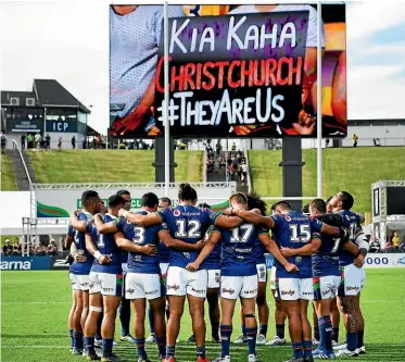  ?? PHOTOSPORT ?? Warriors players huddle for a moment’s silence to support victims of the Christchur­ch mosque shootings.