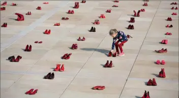  ??  ?? A display of hundreds of red shoes spread as protest against violence toward women in Israel at Habima Square in Tel Aviv, Israel, on Tuesday. AP Photo/oDeD BAlIlty