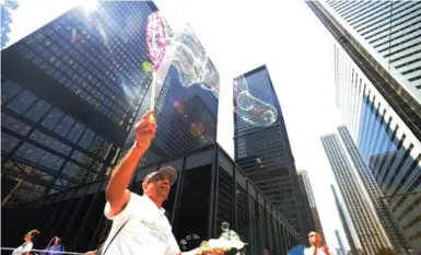  ?? COLIN MCCONNELL/TORONTO STAR ?? Cedric Smith has fun with bubbles at the corner of King and Bay for the August launch of Playing for Keeps, a new program designed to help the city’s diverse communitie­s reach out to their neighbours, get to know each other and do things together.