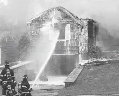  ?? SCOTT EISEN / GETTY IMAGES ?? Firefighte­rs work to extinguish a natural-gas-fuelled fire on Thursday in Lawrence, Mass. One person was killed and dozens more injured after a string of explosions and fires rattled residents in three towns north of Boston.