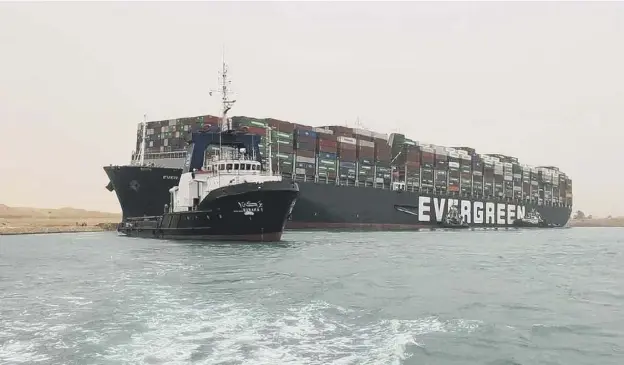  ??  ?? 0 The Taiwan-owned MV Ever Given, a 400m-long and 59-metre wide vessel, lodged sideways impeding all traffic across the waterway of Egypt’s Suez Canal