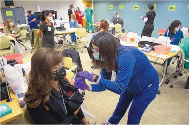  ?? SOURCE: UNIVERSITY OF NEW MEXICO HOSPITAL ?? In this file photo, health care workers at the University of New Mexico Hospital receive their first injections of the COVID-19 vaccine.