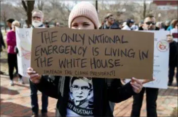  ?? CAROLYN KASTER — THE ASSOCIATED PRESS ?? Cat McKay of Alexandria, Va., holds a sign during a protest organized by “Move On” Monday Lafayette Square near the White House in Washington, to protest that President Donald Trump declared a national emergence along the southern boarder.