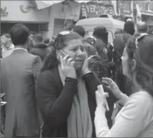  ?? TNS ?? People react at the blast site Sunday after 11 people were killed and 35 others were injured in a suicide bombing near a Coptic church in Alexandria.