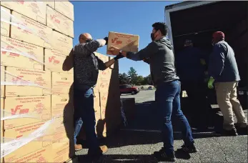  ?? Erik Trautmann / Hearst Connecticu­t Media ?? Volunteers help distribute 1,000 boxes of food to local nonprofit and faith-based organizati­ons to help feed the needy on Oct. 8 at the distributi­on point at Andrews Field in Norwalk. The food is from the USDA, and two tractor-trailers arrived at Andrews Field early that day. DPW staff and volunteers from organizati­ons throughout Norwalk, including Stew Leonard’s and Keystone Community Church, unloaded the pallets of food and distribute­d the USDA Farmers to Families Food Boxes to the organizati­ons to benefit their clients or congregati­ons.