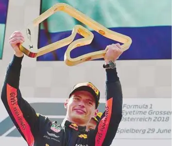  ?? AFP ?? Red Bull’s driver Max Verstappen celebrates with the trophy after winning the Austrian Grand Prix in Spielberg yesterday. Raikkonen and Vettel finished second and third respective­ly.