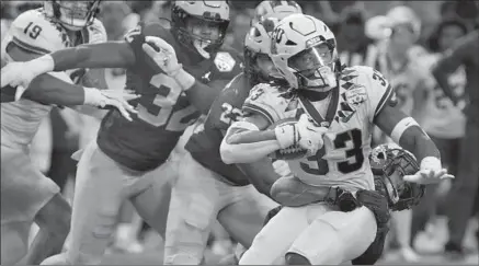  ?? Photograph­s by Rick Scuteri Associated Press ?? KENDRE MILLER of TCU is tackled in first half by Michigan’s DJ Turner. Miller left in the second quarter because of a leg injury.