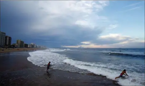  ?? ALEX BRANDON — THE ASSOCIATED PRESS ?? Surfers head to the waves, Tuesday in Virginia Beach, Va., before the arrival of Hurricane Florence.