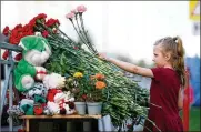  ?? ASSOCIATED PRESS ?? A girl lays flowers near a school after a shooting in Kazan, Russia. Russian officials say the dead in Tuesday’s attack include students, a teacher and a school worker. Nine died in all, with 21 others hospitaliz­ed.