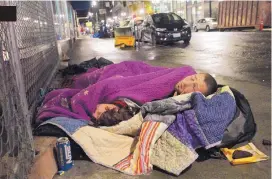  ?? TED S. WARREN ASSOCIATED PRESS ?? Taz Harrington sleeps with his girlfriend, Melissa Ann Whitehead, on a downtown Portland, Ore., street on Sept. 18, 2017. Harrington, in his 20s, met Whitehead, who was already homeless, online and came to Oregon to be with her.