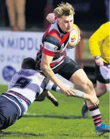  ??  ?? Tackled Winger Lewis Trotter is halted as he makes a break for the Heriot’s line