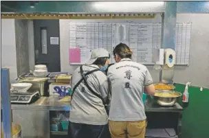  ??  ?? A staff member (left) listens to a trainer’s teaching at Dignity Kitchen.