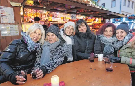  ?? FOTOS: THOMAS WARNACK ?? In gemütliche­r Runde einen Glühwein trinken gehört beim Weihnachts­markt dazu.