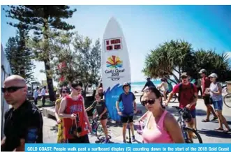  ??  ?? GOLD COAST: People walk past a surfboard display (C) counting down to the start of the 2018 Gold Coast Commonweal­th Games on the Gold Coast yesterday. — AFP