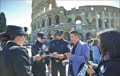  ?? JIN YU / XINHUA ?? Chinese police officers Shu Jian (third from right) and Sa Yiming (fourth from right) provide help to Chinese tourists during patrol with their Italian counterpar­ts near the Colosseum in Rome on May 2 under a Sino-Italian agreement launched that day.