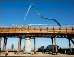  ?? AP PHOTO BY RICH PEDRONCELL­I ?? In this 2017, file, workers pour concrete on to one of the elevated sections of the highspeed rail that will cross over the San Joaquin River, near Fresno.