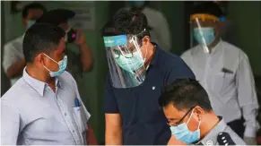  ?? — aFP ?? Facing the law: Lah (centre) being led into the Mayangone Township Court in yangon.