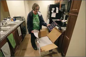  ?? (AP/Rick Bowmer) ?? Ann Lovell opens a box of prescripti­on drugs at her home in South Jordan, Utah, last month after returning from a visit to Tijuana, Mexico.