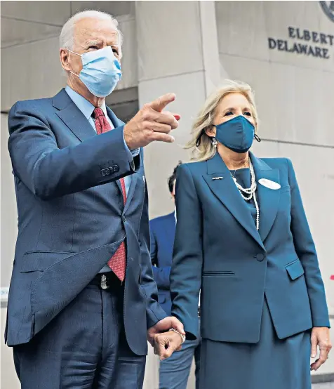  ??  ?? Joe Biden, the Democratic presidenti­al nominee, holds the hand of his wife, Jill, after casting their ballots during early voting in their home town of Wilmington, Delaware