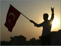  ?? ISMAIL COSKUN — THE ASSOCIATED PRESS ?? A Turkish youth celebrates with a national flag after news about Syrian town of Tal Abyad, in Turkish border town of Akcakale, in Sanliurfa province, Sunday. Turkey’s official Anadolu news agency, meanwhile, said Turkey-backed Syrian forces have advanced into the center of a Syrian border town, Tal Abyad, on the fifth day of Turkey’s military offensive.
