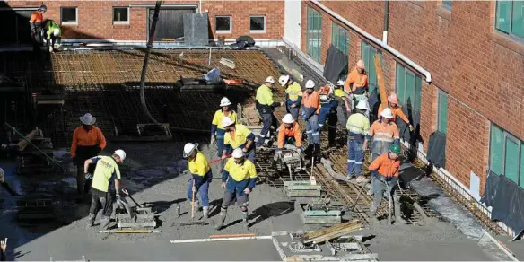  ?? PHOTO: KEVIN FARMER ?? LONG DAY AT THE OFFICE: Hutchinson Builders workers pour concrete for the roof of the new theatres at St Vincent's Private Hospital, a job that took 12 hours.