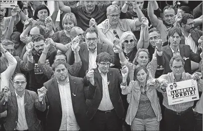  ?? [EMILIO MORENATTI/THE ASSOCIATED PRESS] ?? Catalan President Carles Puigdemont, center, joins a march Saturday in Barcelona to protest the National Court’s decision to replace Catalan leaders. The Spanish government is using a constituti­onal maneuver to take control of Catalonia and derail the...