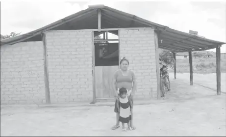  ?? (Ministry of the Presidency photo) ?? This resident stands in front of her home at Itabac Village, which she said was completely under water.