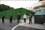  ?? (AP/Ng Han Guan) ?? Security workers on Saturday guard an entrance to Wuhan Jinyintan Hospital, which the World Health Organizati­on team visited as part of its search for the coronaviru­s’s origins in China.