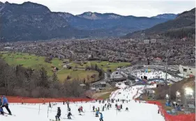  ?? ALESSANDRO TROVATI/AP FILE ?? Athletes inspect the small strip of snow in January where they will race in Garmisch Partenkirc­hen, Germany.