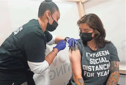  ?? SETH WENIG/AP ?? Denise Padilla gets vaccinated in Secacus, N.J., on Feb. 28. The Centers for Disease Control and Prevention recommends that Americans who have been fully vaccinated still wear masks in public and avoid large gatherings.