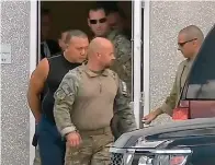  ?? WPLG-TV via AP ?? ■ This frame grab from video provided by WPLG-TV shows FBI agents escorting Cesar Sayoc, in sleeveless shirt, on Friday in Miramar, Fla.