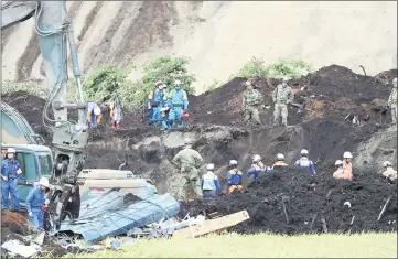  ??  ?? Rescue workers search for missing people in Atsuma. — AFP photos