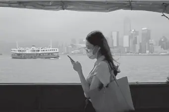  ?? Kin Cheung, The Associated Press ?? A woman uses her cellphone on a ferry in Hong Kong. China’s passage of a national security law for the city is the latest sign that the 50-year “one country, two systems” arrangemen­t that allowed Hong Kong to keep its own legal, financial and trade regimes is perishable.