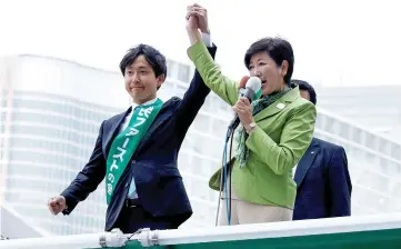  ?? — Reuters photo ?? Koike (right) delivers a speech to voters atop a campaign van as election campaign officially kicks off for Tokyo Metropolit­an Assembly election, on the street in Tokyo in this file picture.