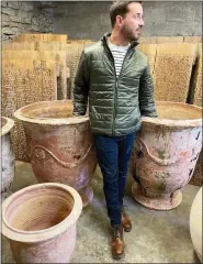  ?? THOMAS GUY INTERIORS VIA AP ?? Louisiana-based designer Lance Thomas poses with 19th Century Anduze planters that can be found at Versailles, and was popular during the reign of Louis XIV. Thomas ships antique French pots like these as well as pre-20th century olive pots, back to use on projects here at home.