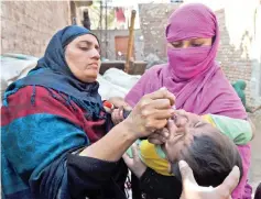  ?? AFP photo ?? A Pakistani health worker administer­s polio vaccine drops to a child during a polio campaign in Lahore in this file photo.—