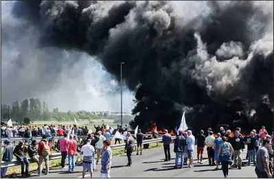  ??  ?? Chaos: French strikers burned tyres to block the Calais entrance to the Eurotunnel yesterday