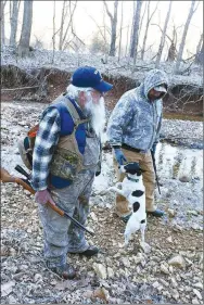  ?? Flip Putthoff/NWA Democrat-Gazette ?? Gary Wellesley (left), Chris Denham and squirrel dog Spec start their hunt Feb. 17 on a frosty morning.