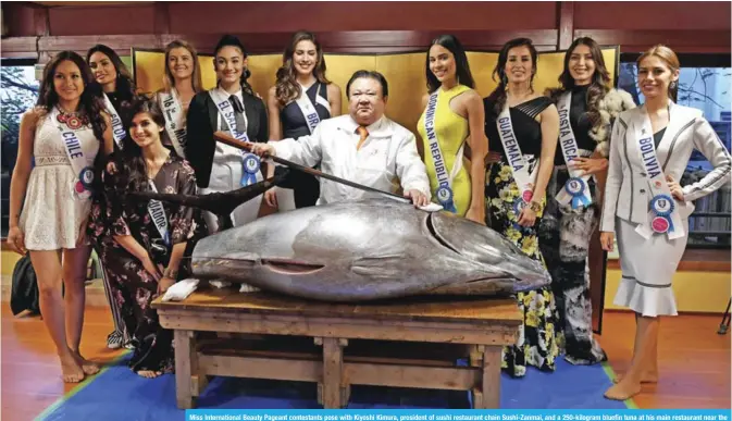  ??  ?? Miss Internatio­nal Beauty Pageant contestant­s pose with Kiyoshi Kimura, president of sushi restaurant chain Sushi-Zanmai, and a 250-kilogram bluefin tuna at his main restaurant near the Tsukiji fish market in Tokyo. 69 contestant­s will compete for the...