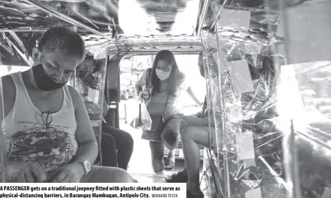  ?? BERNARD TESTA ?? A PASSENGER gets on a traditiona­l jeepney fitted with plastic sheets that serve as physical-distancing barriers, in Barangay Mambugan, Antipolo City.