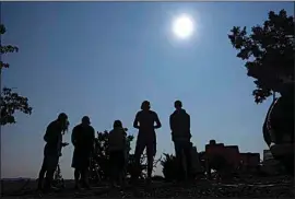  ?? TED S. WARREN / AP ?? People gather on Aug. 21, 2017 near Redmond, Ore., to view the sun as it nears a total eclipse by the moon.