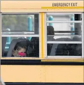  ?? NAM Y. HUH/AP ?? Elementary school students sit on board a school bus after attending in-person classes at school Thursday in Wheeling. Several Illinois schools will go to virtual remote learning after Thanksgivi­ng weekend as COVID-19 cases soar.