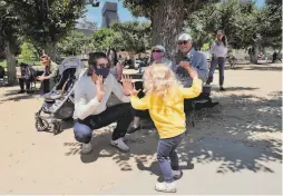  ??  ?? Orla Magee, 2, dances to the music with her father, Riley Magee. The band’s tradition of Sunday concerts in the park goes back to 1882.