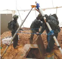  ?? REUTERS ?? ISRAELI SOLDIERS lift the cover of an Israeli-dug hole into a cross-border tunnel dug from Lebanon into Israel, as seen on the Israeli side of the border, near the town of Metula, in this Dec. 19, 2018 photo.