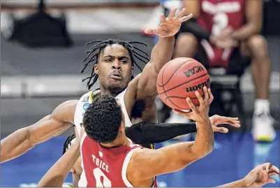  ?? Michael Conroy / Associated Press ?? Baylor guard Davion Mitchell blocks the shot of Wisconsin guard D'mitrik Trice in the second half of a second-round game in the NCAA Tournament at Hinkle Fieldhouse in Indianapol­is on Sunday. Mitchell led the Bears with 16 points.