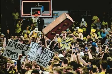  ?? GETTY ?? Wake Forest fans storm court after upset victory and Duke center Kyle Filipowski ends up with knee injury.